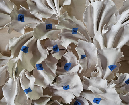 The artwork 'Force of Nature' in progress. This artwork is made up of almost eighty ceramic pieces overlaying each other and placed on a background of structural ply.