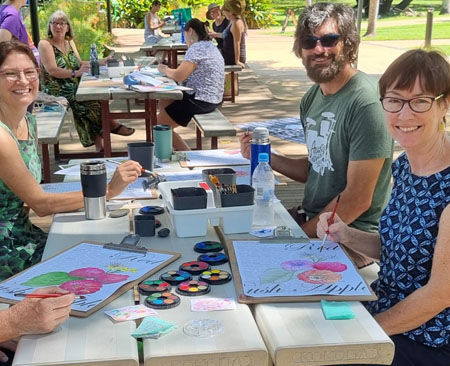 Adults enjoying an art workshop at Darwin's Botanic Gardens.