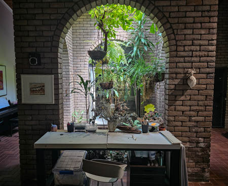 Studio table in front of an arched garden atrium.