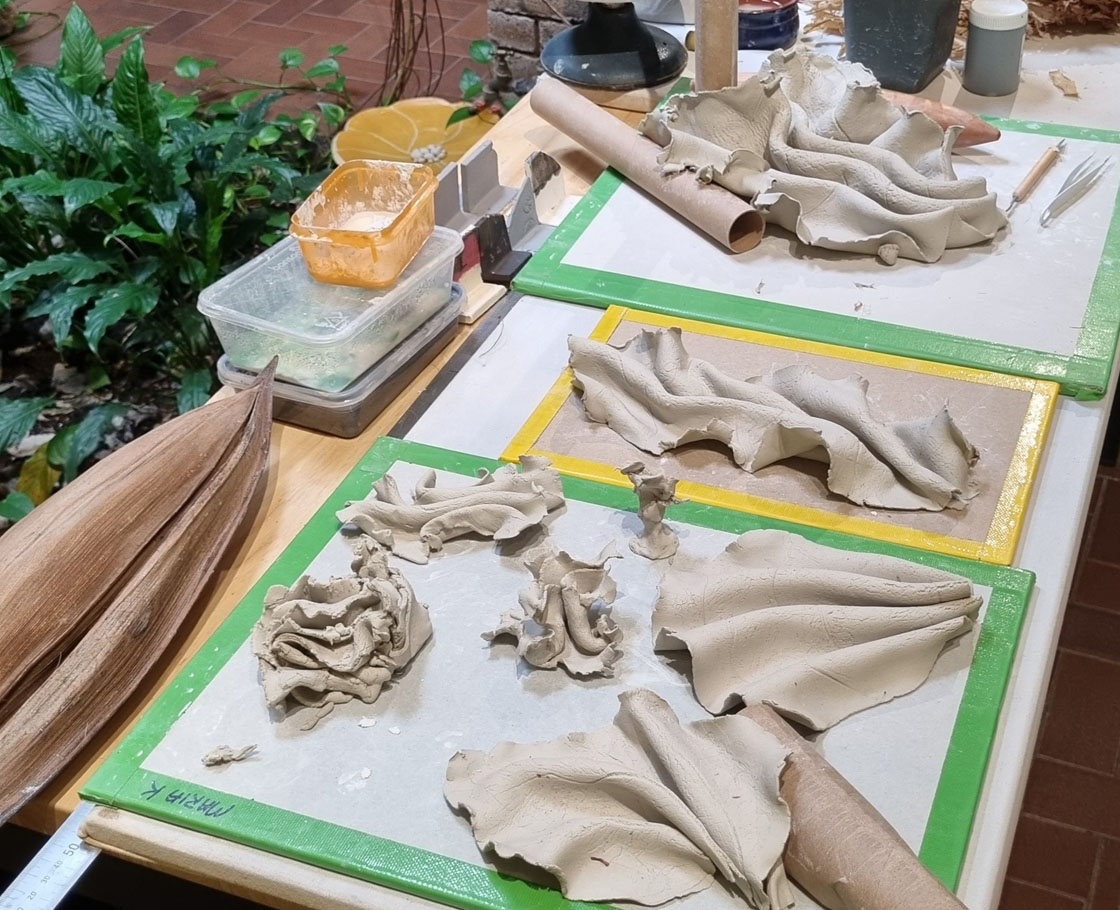 The artist's work table showing some experimentation in clay folding.