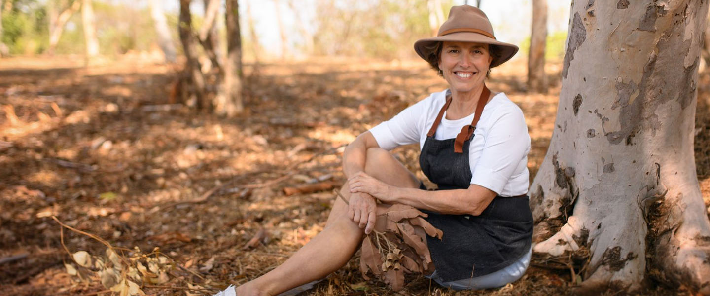 Artist Maria Kraatz sitting in shade of eucalyptus trees in a park.