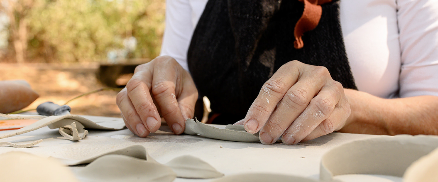 Detail of artist working with clay.