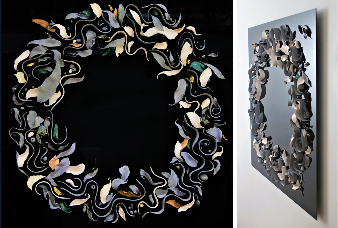 An artwork by Maria Kraatz made up of ceramic leaves, curving lines, stylised fish, pebbles and gum nuts laid in a broad circle on a black glass background.