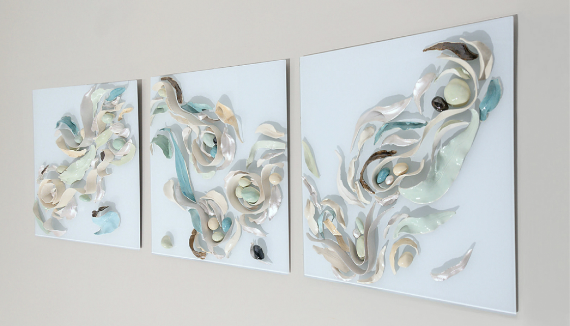 A three-panel ceramic-on-glass artwork by Maria called 'Stream'. Many ribbons, leaves, and pebbles evoke the flow of water in a tropical Top End stream in the Northern Territory.